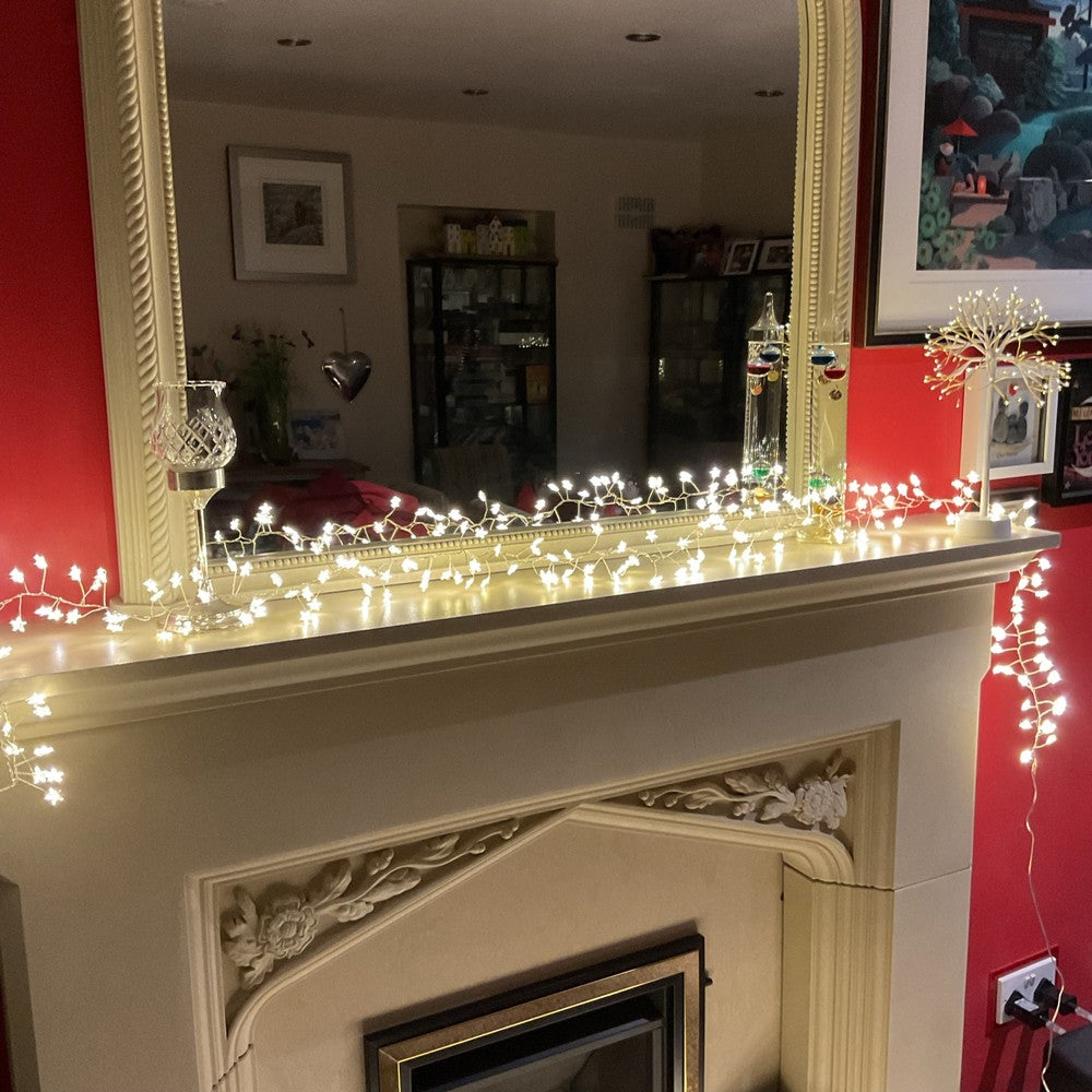 2.2m warm white star cluster Christmas lights on fireplace mantel