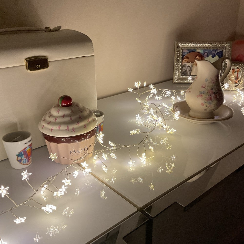 Warm white LED Christmas star lights on sideboard
