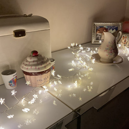 Warm white LED Christmas star lights on sideboard